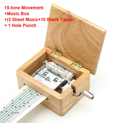 Boîte à musique rectangulaire en bois ouverte, avec mécanisme apparent. Une bande perforée sort sur le côté.
