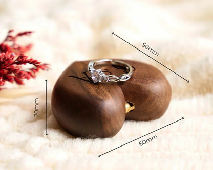 Boîte à bague en bois de noyer en forme de cœur, gravée, de 60x50x20 mm, avec une bague en argent ornée.