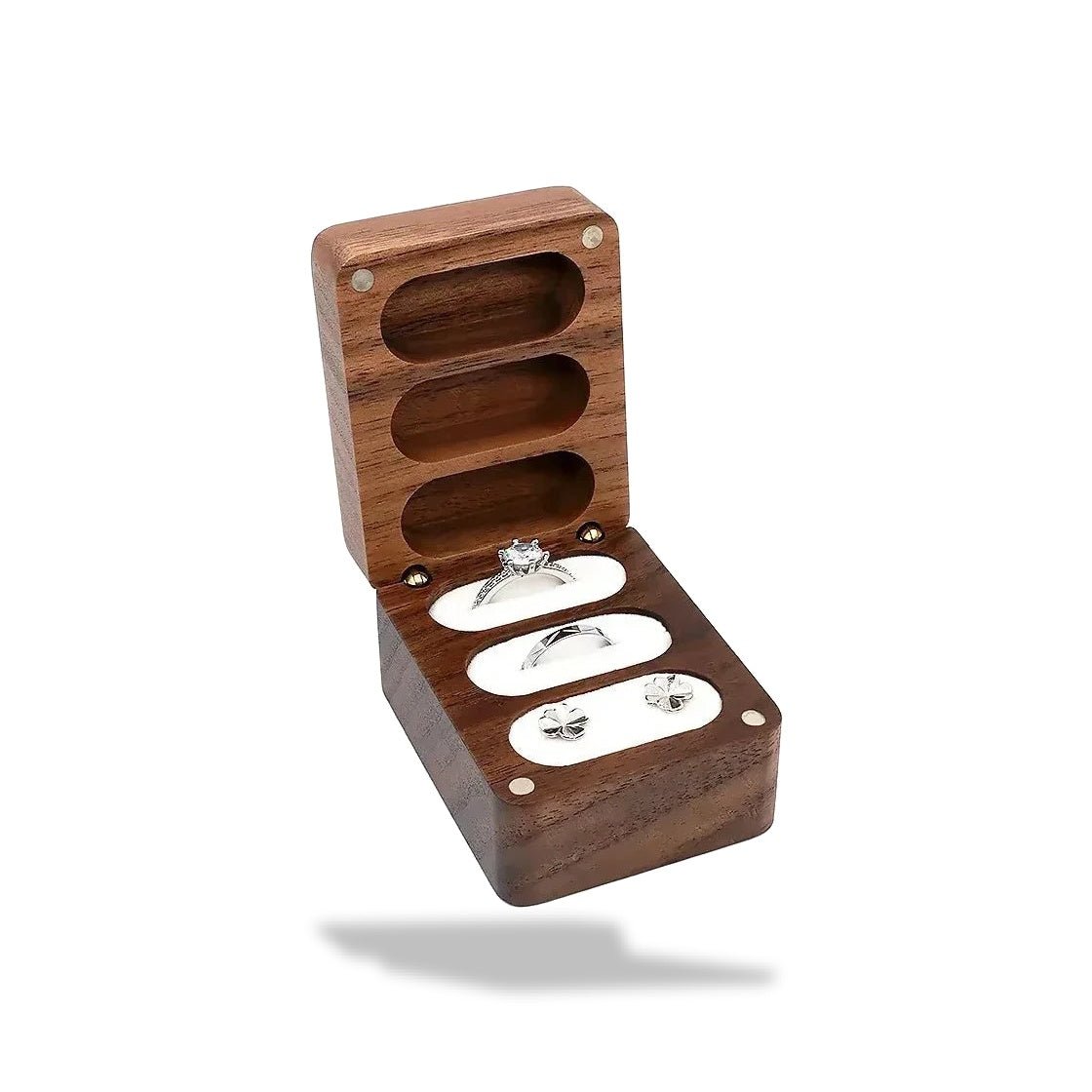Boîte à bijoux ouverte en bois de noyer foncé avec trois emplacements. Deux anneaux argentés et une paire de boucles d'oreill