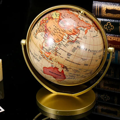 Globe terrestre décoratif avec carte du monde aux tons chauds, monté sur un support doré en métal.