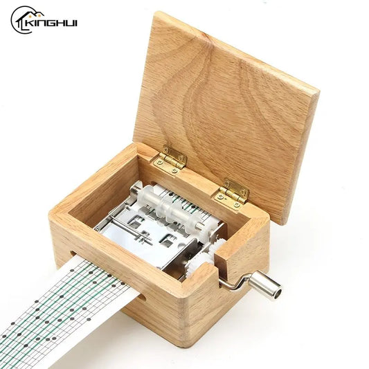 Boîte à musique personnalisable en bois clair, couvercle ouvert, avec mécanisme métallique et manivelle sur le côté. Une band
