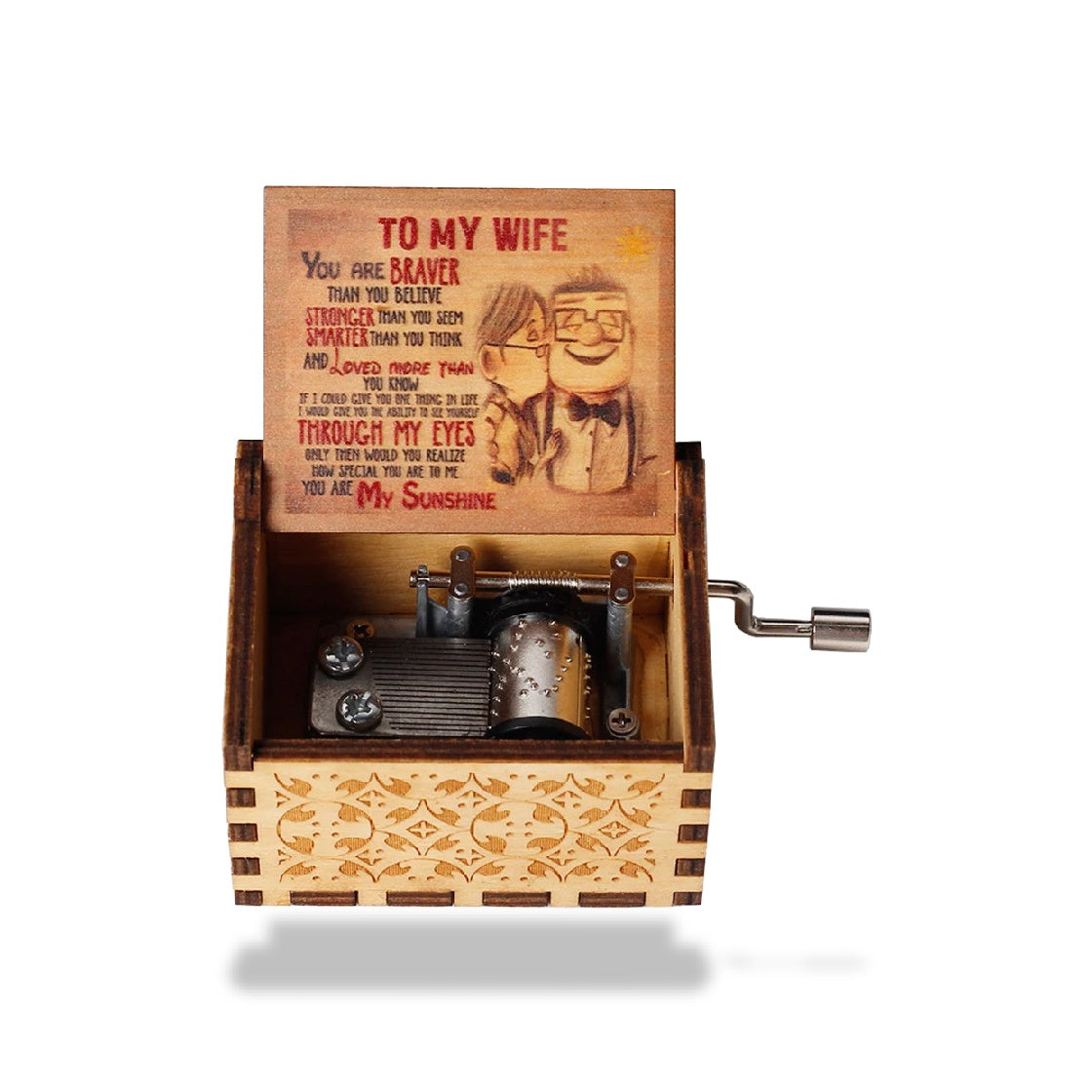 Boîte à musique en bois clair ouverte, mécanisme en métal visible, couvercle gravé avec un couple de dessins animés et le tex