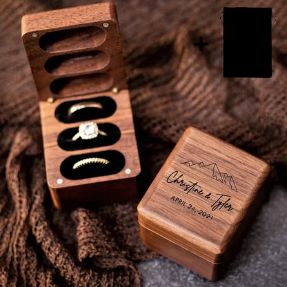 Deux boîtes à bagues en bois de noyer. L'une ouverte avec trois anneaux, l'autre fermée et gravée.