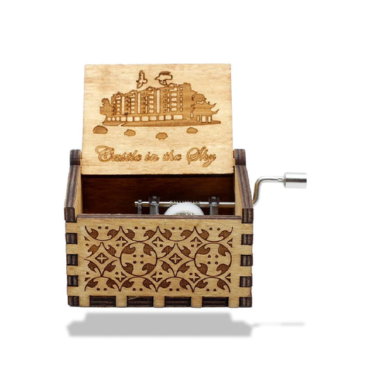 Boîte à musique en bois clair avec un motif gravé sur le devant et sur le couvercle ouvert. Une manivelle métallique est visi