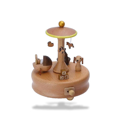 Boîte à musique carrousel enfant en hêtre avec socle rond. Présence d'un berceau et d'un chien sculptés, ainsi que des lettre