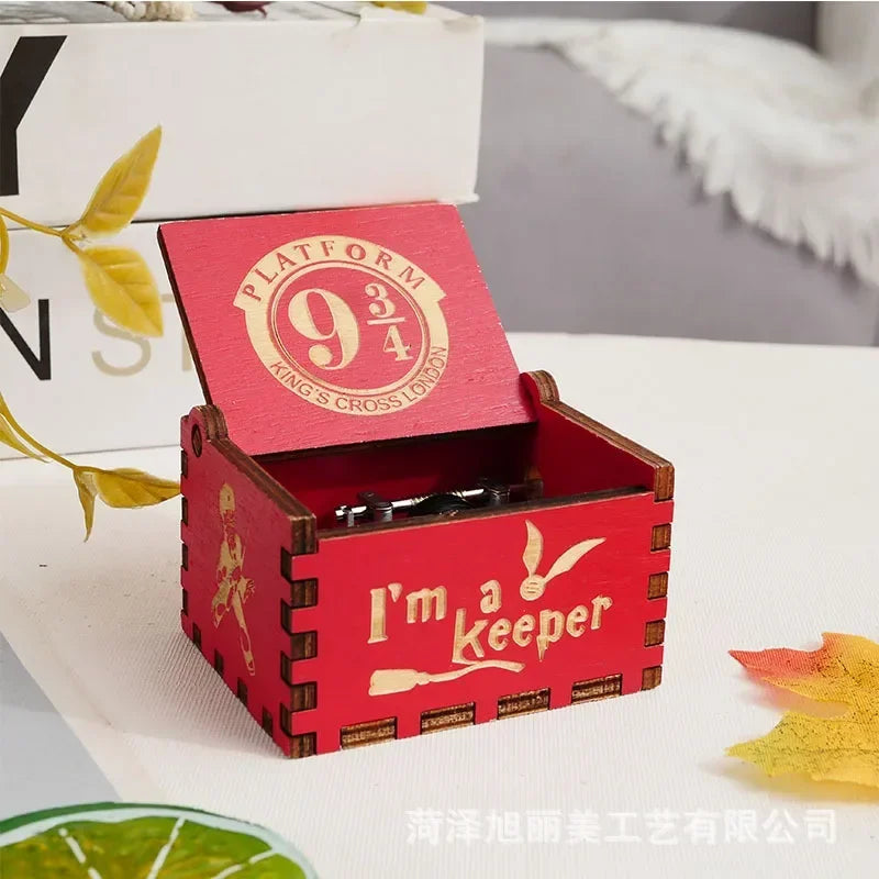 Boîte à musique rouge en bois, couvercle ouvert, avec le logo Platform 9 3/4 et l'inscription 'I'm a Keeper'.