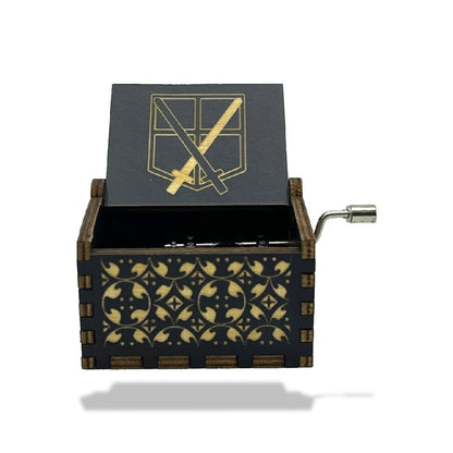Boîte à musique en bois noire, motif géométrique doré, avec manivelle et symbole de l'Attaque des Titans.