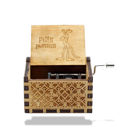 Boîte à musique en bois avec manivelle, motif de la Panthère Rose et texte gravé sur le couvercle ouvert.